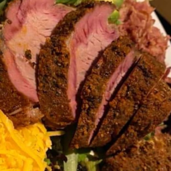 Holy Smokes' sliced BBQ meat, seasoned with spices, served with shredded cheese and coleslaw.