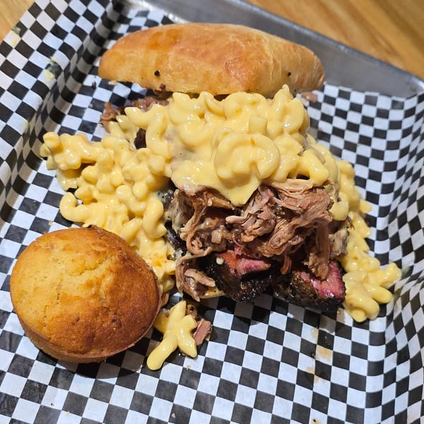 Holy Smokes BBQ sandwich with pulled pork, brisket, mac and cheese, and a cornbread muffin.